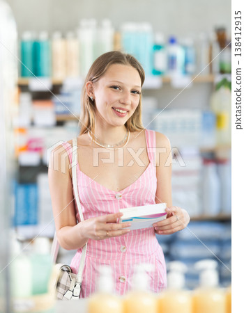 Girl in summer clothes looking for medicine in pharmacy 138412915