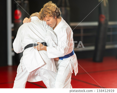Karate with male athletes practicing, training and sparring in fight class 138412919