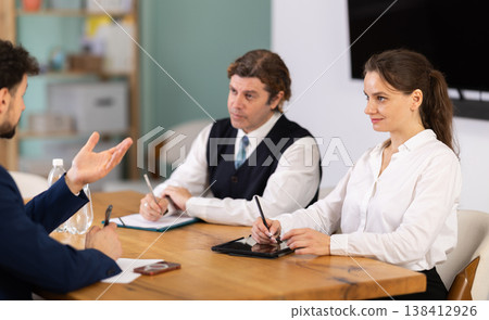 Business professionals discussing topic during corporate meeting at table Business professionals discussing topic during corporate meeting at table 138412926