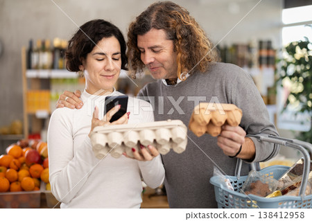 Woman and man scanning eggs in store Woman and man scanning eggs in store 138412958