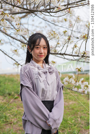 年輕女子在櫻花樹下微笑的肖像。 年輕女子在櫻花樹下微笑的肖像。 138412986