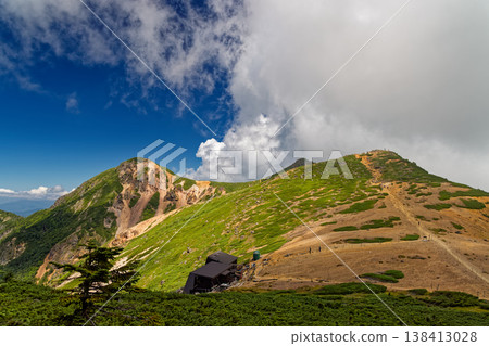 The Yatsugatake mountain range in summer, with its rising clouds, including Mt. Neishi and Mt. Tengu. 138413028