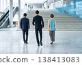一群商務人士的背影走過一棟現代化的辦公大樓。 一群商務人士的背影走過一棟現代化的辦公大樓。 138413083