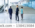 一個商務團隊走向辦公大樓的樓梯,一個微笑的男人轉過身來。 一個商務團隊走向辦公大樓的樓梯,一個微笑的男人轉過身來。 138413084