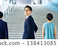 一位身穿西裝的日本商人面帶自信地轉身站在樓梯前。 一位身穿西裝的日本商人面帶自信地轉身站在樓梯前。 138413085