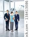 三位面帶微笑的日本男女商務團隊成員站在辦公大樓大廳;全身照。 三位面帶微笑的日本男女商務團隊成員站在辦公大樓大廳;全身照。 138413086