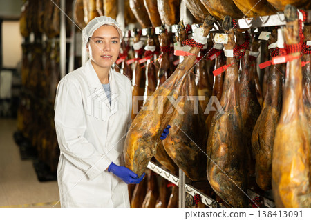 Girl checks quality of spanish jamon in workshop 138413091