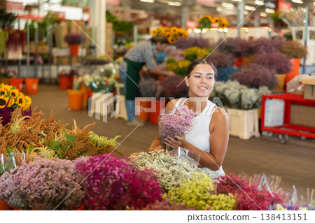Young woman choosing bouquet of dried flowers Young woman choosing bouquet of dried flowers 138413151
