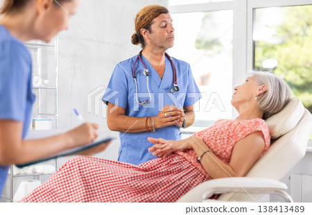 Female nurse and male doctor carries out survey of mature female patient about allergic reactions Female nurse and male doctor carries out survey of mature female patient about allergic reactions 138413489