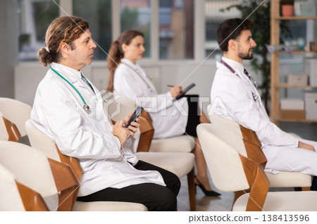Medical students or doctors attending training session in modern lecture room Medical students or doctors attending training session in modern lecture room 138413596