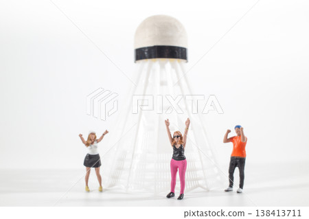 Miniature figures cheering near oversized shuttlecock sculpture Miniature figures cheering near oversized shuttlecock sculpture 138413711