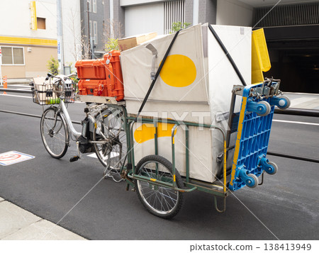 Delivery service: Electric bicycle with a towable cargo rack. 138413949