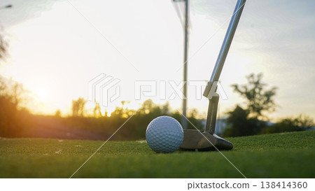 Golf clubs and balls on a green lawn in a beautiful golf course with morning sunshine. 138414360