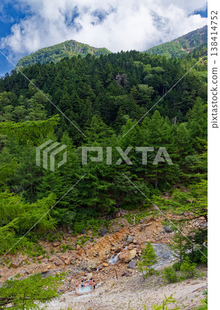 The open-air bath at Honzawa Onsen in the Yatsugatake mountain range and the mountain scenery with clouds rising. The open-air bath at Honzawa Onsen in the Yatsugatake mountain range and the mountain scenery with clouds rising. 138414752