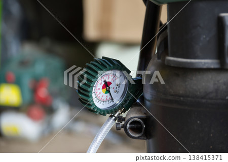 Close-up of an air compressor pressure gauge showing readings in psi and bar Close-up of an air compressor pressure gauge showing readings in psi and bar 138415371