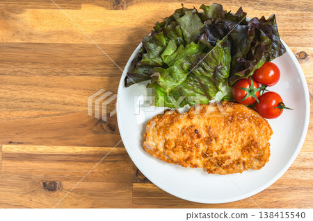 一盤味噌醃豬排,配上鮮嫩的生菜和櫻桃番茄。家常菜,盛於潔白的餐盤之中。 一盤味噌醃豬排,配上鮮嫩的生菜和櫻桃番茄。家常菜,盛於潔白的餐盤之中。 138415540