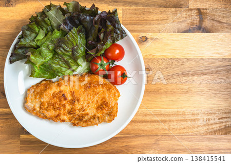 一盤味噌醃豬排,配上鮮嫩的生菜和櫻桃番茄。家常菜,盛於潔白的餐盤之中。 一盤味噌醃豬排,配上鮮嫩的生菜和櫻桃番茄。家常菜,盛於潔白的餐盤之中。 138415541