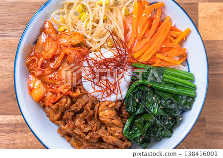 韓式拌飯,配上溏心蛋、蔬菜和豬肉:一道色彩繽紛的韓國蓋飯。 韓式拌飯,配上溏心蛋、蔬菜和豬肉:一道色彩繽紛的韓國蓋飯。 138416001