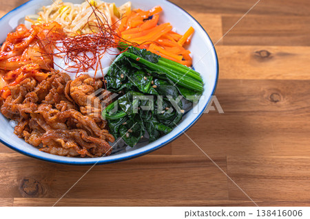 韓式拌飯,配上溏心蛋、蔬菜和豬肉:一道色彩繽紛的韓國蓋飯。 韓式拌飯,配上溏心蛋、蔬菜和豬肉:一道色彩繽紛的韓國蓋飯。 138416006