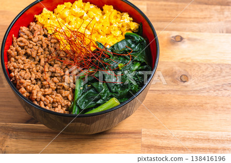 Three-color rice bowl: Japanese-style rice bowl with minced chicken, egg, and spinach. Three-color rice bowl: Japanese-style rice bowl with minced chicken, egg, and spinach. 138416196