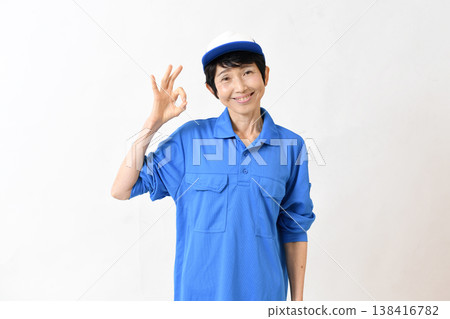 一位中年女工比出「OK」手勢。 一位中年女工比出「OK」手勢。 138416782