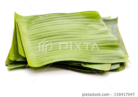 Stacked banana leaves on a white background, commonly used in traditional cooking. 138417047