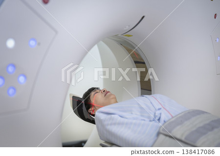 Middle-aged woman undergoing head CT scan 138417086