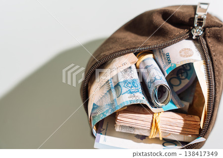 Open brown pouch with Kazakhstani tenge banknotes bundles, cash savings and financial security concept Open brown pouch with Kazakhstani tenge banknotes bundles, cash savings and financial security concept 138417349