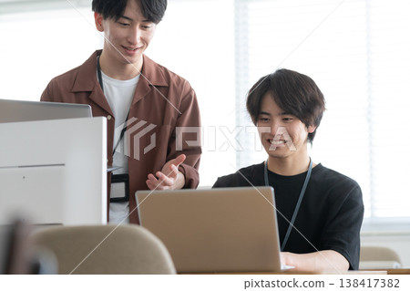 A young male engineer working on his office computer. A young male engineer working on his office computer. 138417382