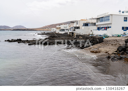 A scenic view captures the coastal charm of Punta Mujeres, Lanzarote, showcasing white buildings and the serene ocean. A scenic view captures the coastal charm of Punta Mujeres, Lanzarote, showcasing white buildings and the serene ocean. 138418267