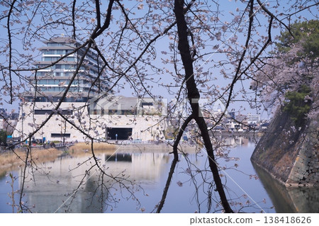 A view of the Espacio Nagoya Castle Hotel through the fully bloomed cherry blossoms. A view of the Espacio Nagoya Castle Hotel through the fully bloomed cherry blossoms. 138418626