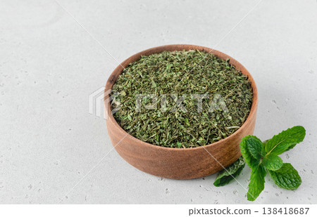 Dried mint leaves in wooden bowl, fresh mint on white background. For tea, cooking, herbal medicine. Dried mint leaves in wooden bowl, fresh mint on white background. For tea, cooking, herbal medicine. 138418687