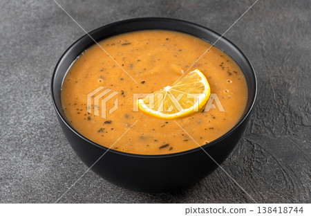 Turkish lentil soup ezogelin with lemon and dried mint on a gray background. close up. 138418744