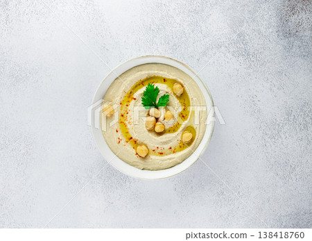 Chickpeas hummus olive oil parsley in white bowl on white background. Healthy vegan food concept Chickpeas hummus olive oil parsley in white bowl on white background. Healthy vegan food concept 138418760