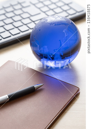 一台電腦、一台筆記型電腦和一台玻璃地球儀 一台電腦、一台筆記型電腦和一台玻璃地球儀 138418875