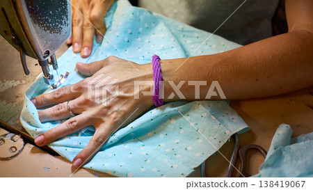 Sewing machine and working women hands of a tailor 138419067