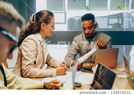 Focused group negotiates insights with charts and notes displayed 138419232