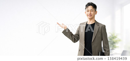一位男商人用手掌指路。 一位男商人用手掌指路。 138419439