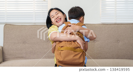 Mother hugging her child with a backpack at home 138419595
