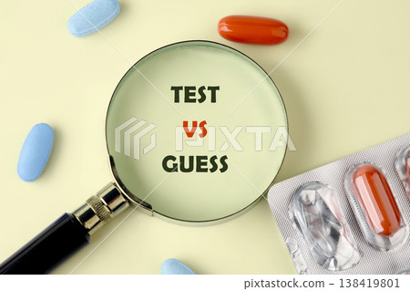 A magnifying glass focuses on TEST VS GUESS on a pale yellow surface A magnifying glass focuses on TEST VS GUESS on a pale yellow surface 138419801