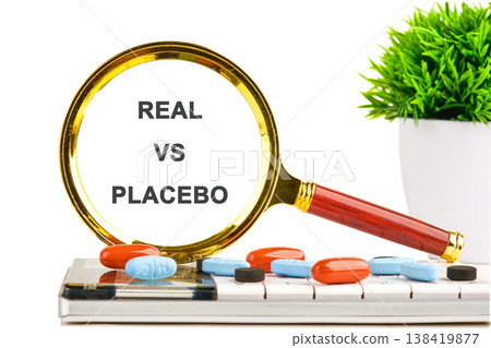 A close up view captures a gleaming magnifying glass highlighting the critical words real versus placebo on a clean surface with various colorful capsules A close up view captures a gleaming magnifying glass highlighting the critical words real versus placebo on a clean surface with various colorful capsules 138419877