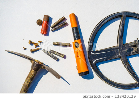 Metal detecting equipment gear and found items displayed on a white surface. Hobby and activity 138420129