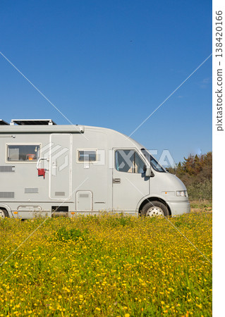 Camping car rv parked close to spring meadow with yellow flowers with blue sky during daytime Camping car rv parked close to spring meadow with yellow flowers with blue sky during daytime 138420166