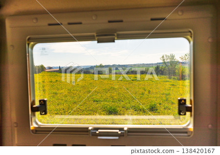 View from a window of a vehicle showing a large yellow flower field under a clear sky in a rural area View from a window of a vehicle showing a large yellow flower field under a clear sky in a rural area 138420167