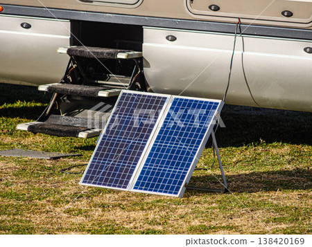 Portable solar photovoltaic panel, charging battery at camper vehicle. Portable solar photovoltaic panel, charging battery at camper vehicle. 138420169