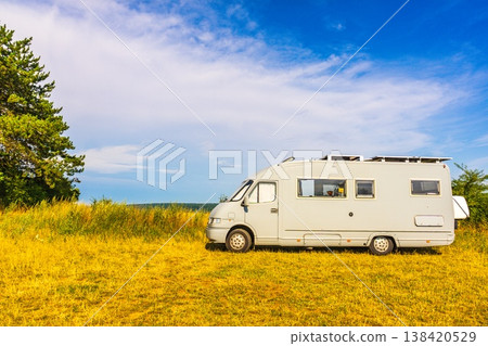 Camping car rv parked close to spring meadow with yellow flowers with blue sky during daytime 138420529