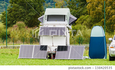 Solar setup in a field with tent and vehicle for camping during daytime Solar setup in a field with tent and vehicle for camping during daytime 138420535