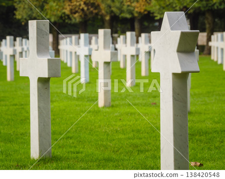 Gravestones stand in a cemetery with a star of David among crosses in the grassy field Gravestones stand in a cemetery with a star of David among crosses in the grassy field 138420548