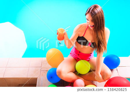 Happy woman with balloons and cocktail at poolside 138420825