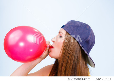 Teen girl blowing red balloon. Teen girl blowing red balloon. 138420885